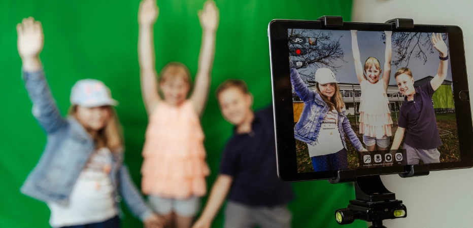 iPad-Fotoaufnahme von Schülern vor dem Greenscreen