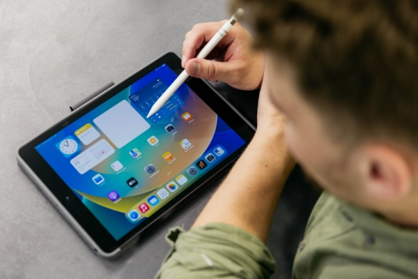 Eine Person tippt mit einem Stift auf einem Tablet herum